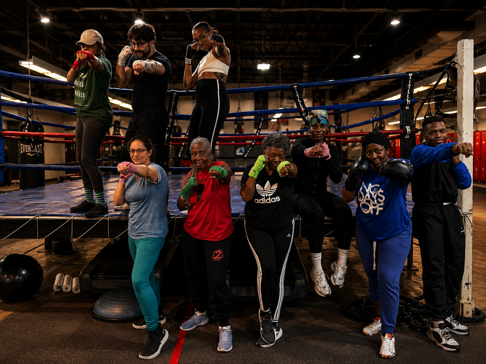 Adult boxing class members in their stances by the 2 Tone ring