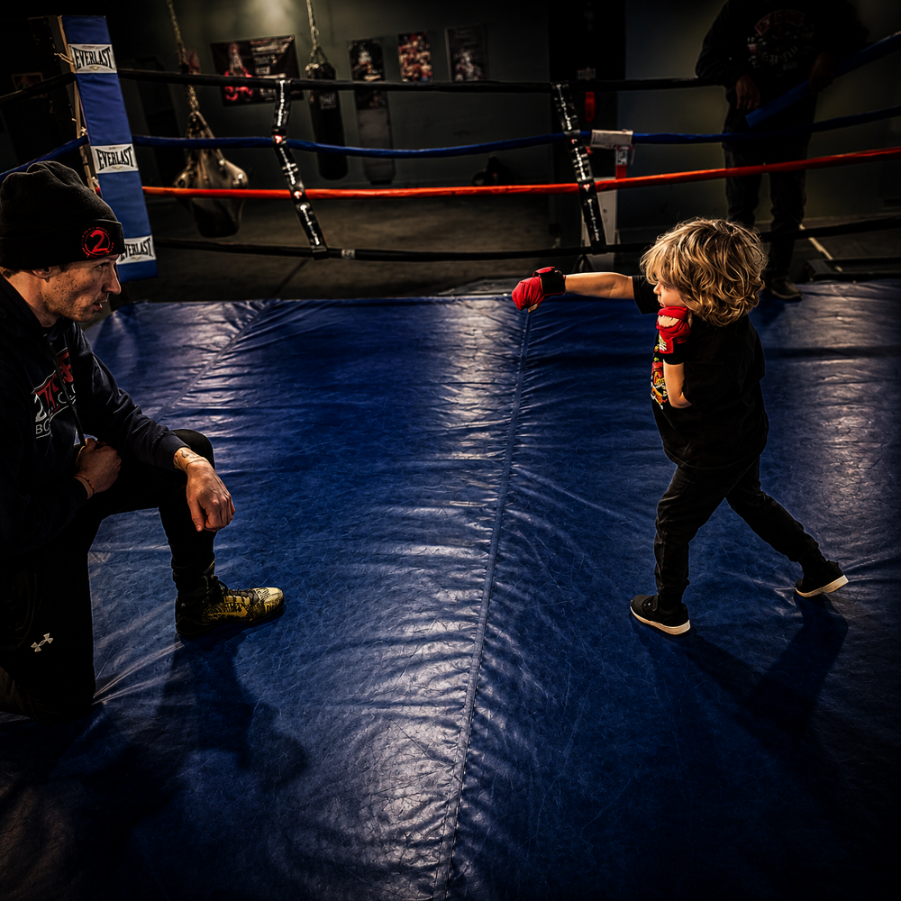 Young child learning to box with a 2 Tone coach